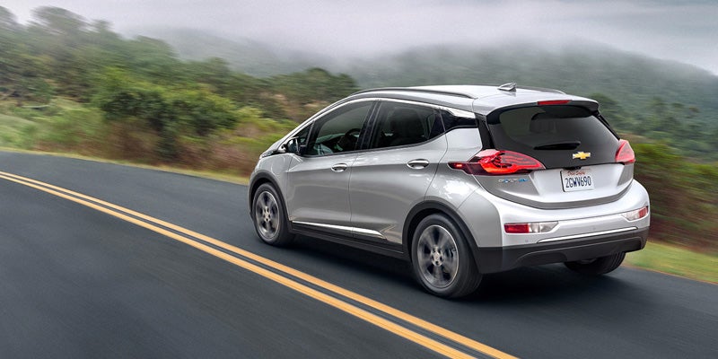 2025 Chevy Bolt EV driving on a road.