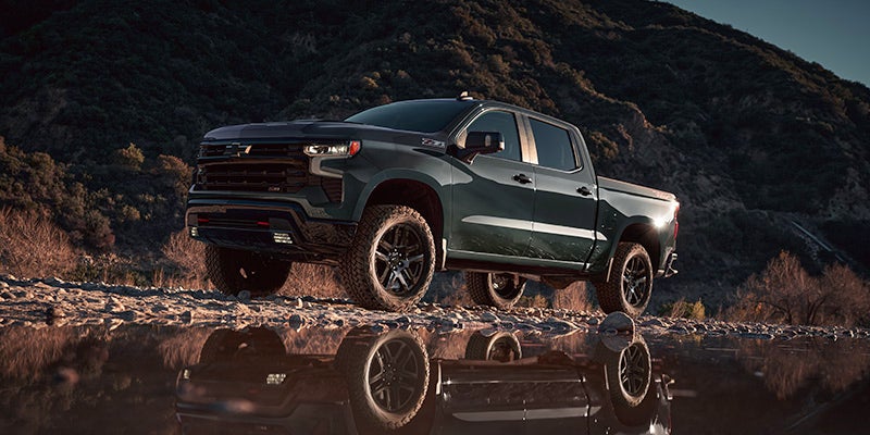 Chevrolet Silverado 1500 driving through rocky water - Gunn Chevrolet in Selma TX