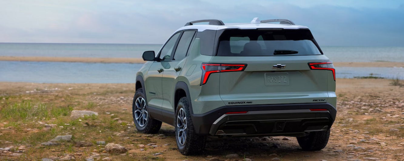 The back of a light green 2026 Chevrolet Equinox SUV parked by a lake