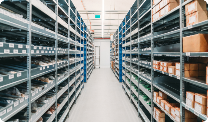 A spacious warehouse aisle featuring tall shelves filled with numerous boxes, providing a clear path for navigation.