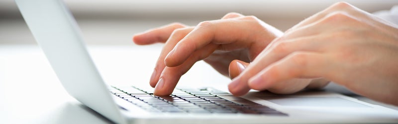 upclose image of someone using laptop - Gunn Chevrolet in Selma TX