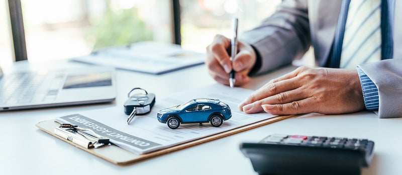 upclose image of someone signing documents - Gunn Chevrolet in Selma TX